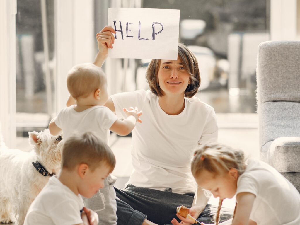 Gestresste Mutter hält ein Hilfesuchendes Blatt in der Hand inmitten ihrer Kinder_Veranstaltung "Stress reduzieren im Familienleben" am Samstag, 17. Juni